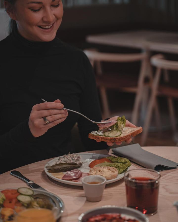 Valo Hotel & Work Helsinki Esterno foto A woman eating a plate of food